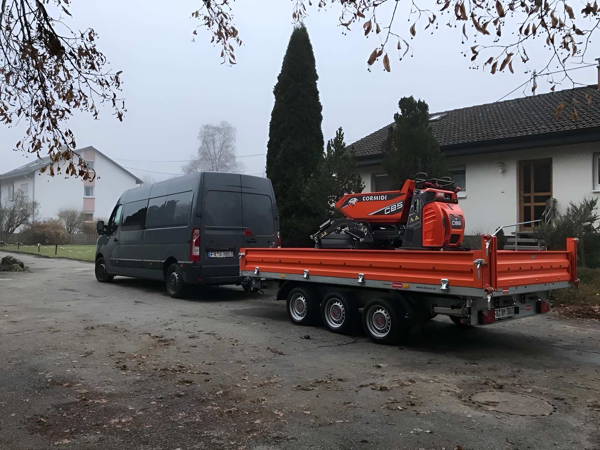 Transporter von Maier Bauservice mit Anhänger und orangefarbenem Raupendumper