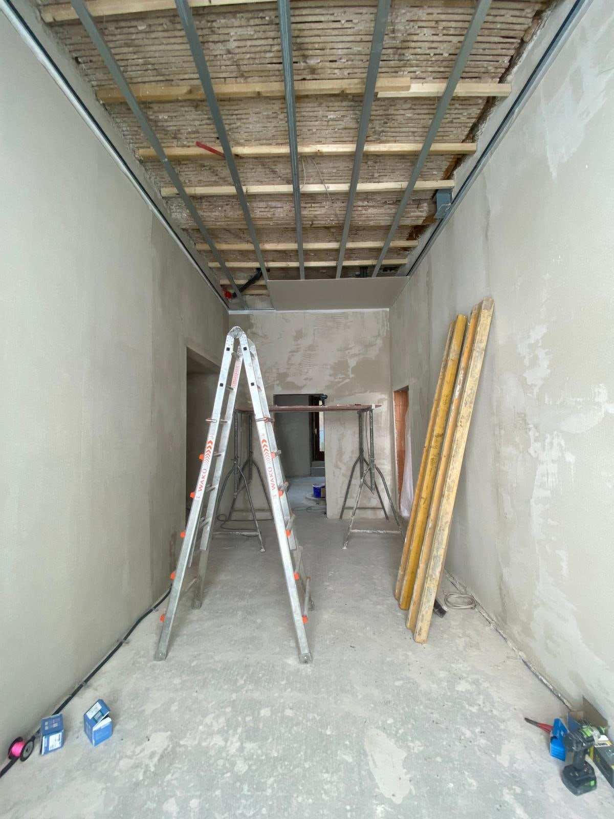 Flur im Umbau: Unterkonstruktion aus Metallprofilen für eine neue Decke, Leiter und Arbeitsböcke